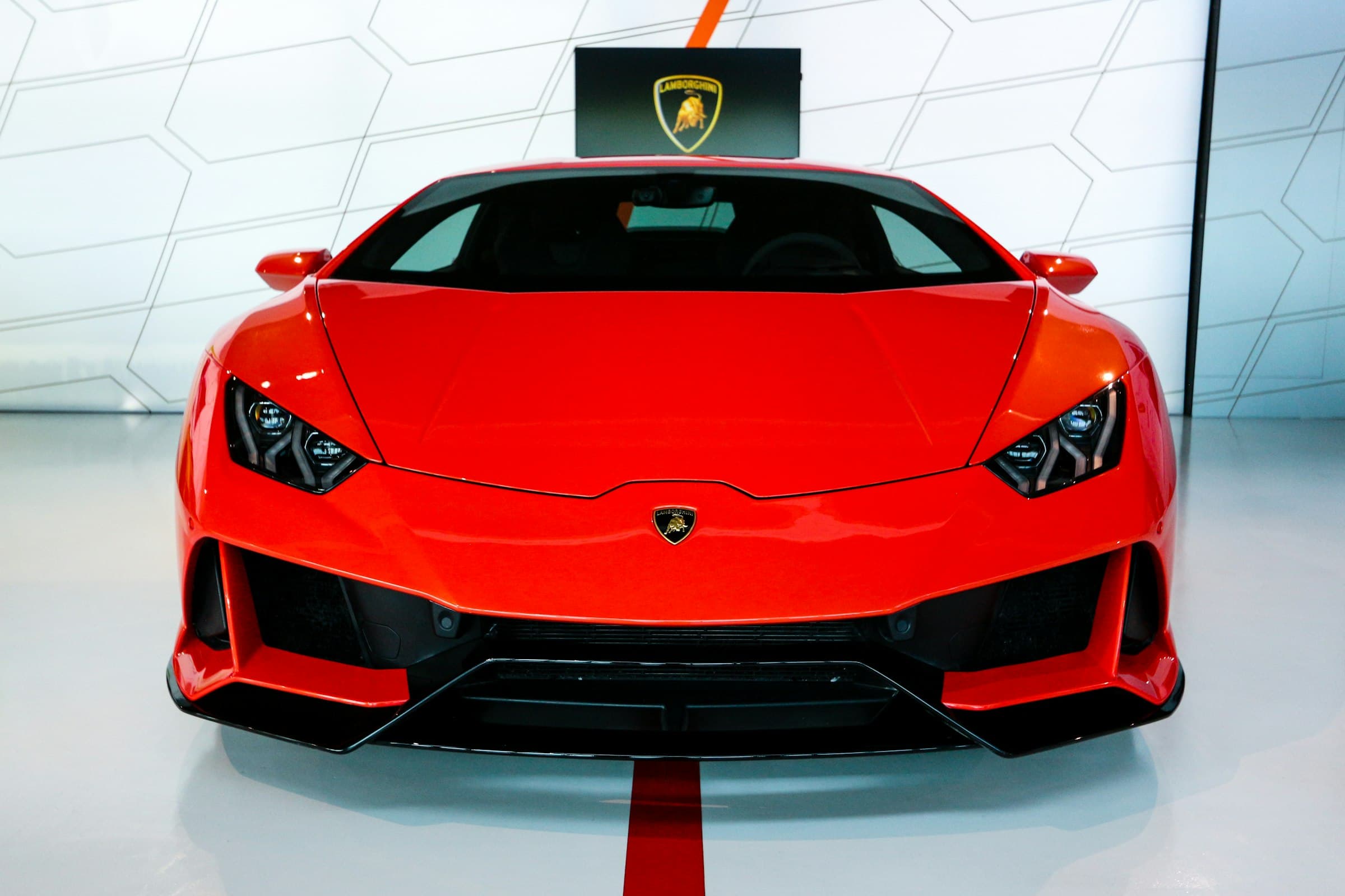Red Lamborghini Huracán EVO photographed head-on in a white showroom